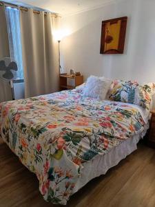 a bedroom with a bed with a colorful quilt on it at Apartamento en las alturas, santiago! in Santiago