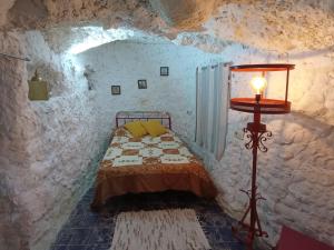 sypialnia z łóżkiem w kamiennej ścianie w obiekcie Mirasierra w mieście Bedmar