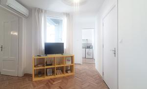 a living room with a tv on a shelf and a door at Apartment Balabanov in Varna City