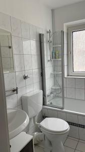 een witte badkamer met een toilet en een wastafel bij FeWo Oberhausen-Alstaden (Gornig) in Oberhausen