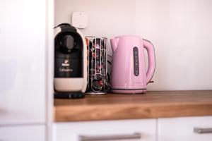 a pink appliance sitting on top of a kitchen counter at Marywilska apartment in Warsaw