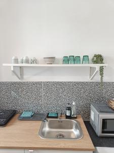 a kitchen counter with a sink and a microwave at Apartment Balabanov in Varna City