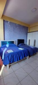 a bedroom with two beds with blue sheets on them at Hostal El Paraiso in Tarija