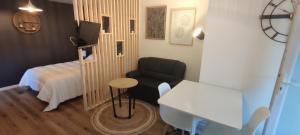 Zimmer mit einem Bett, einem Stuhl und einem Tisch in der Unterkunft Studio Bidehegia in Souraïde