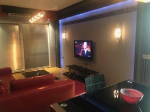 uma sala de estar com um sofá vermelho e uma televisão em Korali Apartment em Ohrid