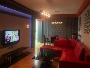 a living room with a red couch and a tv at Korali Apartment in Ohrid