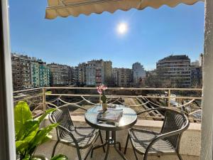 un tavolo e sedie su un balcone con vista sulla città di DoorMat#6 Domus Dei a Salonicco
