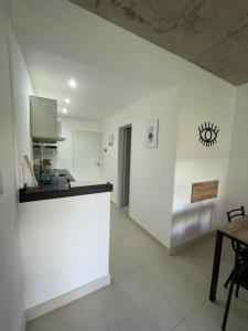 una cucina bianca con bancone e tavolo di Monoambiente en zona céntrica a Rosario