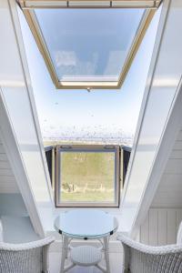 a skylight in a house with a table and two chairs at Villa Nieuwland B&B in Den Oever