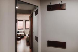 pasillo que conduce a una sala de estar con espejo en Hotel Castrum en Skopie
