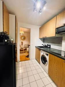 a kitchen with a black refrigerator and a dishwasher at Chic Apartment on the famous shopping Rue du Faubourg Saint-Honoré street in Paris