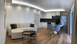 uma sala de estar com um sofá, uma mesa e cadeiras em Apartmán pod Plešivcem em Abertamy