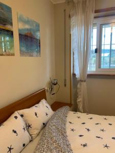 - une chambre avec un lit doté d'oreillers et d'une fenêtre dans l'établissement Sunset Apartment, à Santa Marinella
