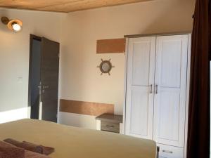 a bedroom with a bed and a white cabinet at Apartmany Rogoznica in Rogoznica