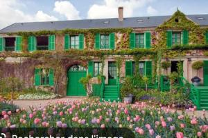 a green house with flowers in front of it at La framboisette in Le Vaudreuil
