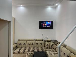 uma sala de estar com um sofá e uma televisão na parede em Berti’s apartaments em Durrës