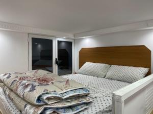 um quarto com uma cama grande e uma cabeceira em madeira em Berti’s apartaments em Durrës