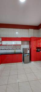 a kitchen with red cabinets and a white tile floor at Hostal El Paraiso in Tarija