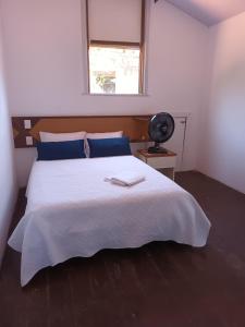 1 dormitorio con 1 cama blanca grande y ventana en Hostel Nossa Sra de Lourdes, en Salvador