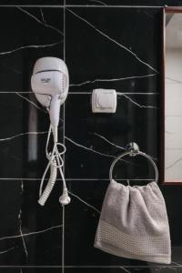 secador de pelo y bolso en la pared en Hotel Castrum en Skopie