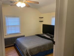 a bedroom with a bed and a ceiling fan at Luke's Hostel in Albany