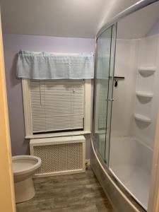 a bathroom with a glass shower and a toilet at Luke's Hostel in Albany