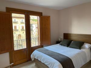 1 dormitorio con cama y ventana grande en Morella, confort y excelentes vistas Casa Joanes en Morella