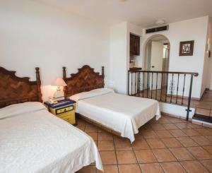 - une chambre avec deux lits et une table avec une lampe dans l'établissement Hotel Villas Los Angeles, à Manzanillo