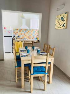 a kitchen with a wooden table with chairs and a table at Casa Gigé in Ustica +3 photos