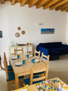 ein Esszimmer mit einem Tisch und einem blauen Sofa in der Unterkunft Casa Gigé in Ustica