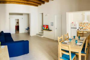 a living room with a table and a blue couch at Casa Gigé in Ustica