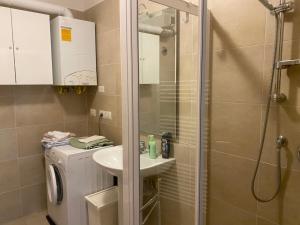 une salle de bain avec douche et lavabo et une machine à laver dans l'établissement La casa di Giacomo con parcheggio, à Trieste 15 autres photos