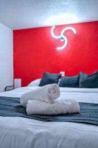 a hotel room with two beds with a red wall at Cosy Mezzanine in Bussy-Saint-Georges