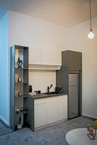 a kitchen with white cabinets and a refrigerator at Magnolija Apartments in Bitola