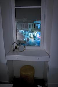 okno z lustrem i krzesłem w pokoju w obiekcie Magnolija Apartments w mieście Bitola