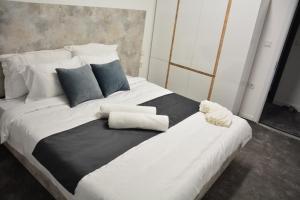 duże łóżko z czarno-białą pościelą i poduszkami w obiekcie Magnolija Apartments w mieście Bitola