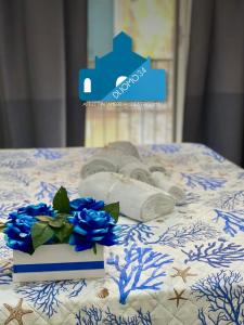 ein blau-weißes Bett mit Handtüchern und blauen Rosen in der Unterkunft Duomo 34 Guest Room in Neapel