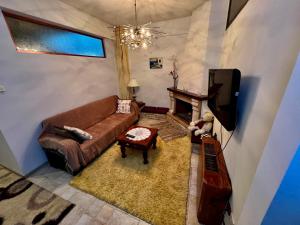 salon z kanapą i telewizorem w obiekcie Όμορφο Κατάλυμα στην Άνω Πόλη Πάτρας w mieście Patras