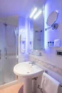 a bathroom with a white sink and a shower at Hotel Royal in Bolsena