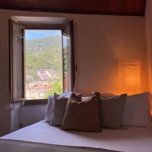 a bedroom with a bed with a large window at Historic Downtown Home By The Sea With King Bed in Monterosso al Mare