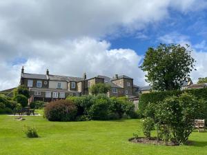 a large building with a green lawn in front of it at Apartment 1 Sneaton Hall in Sneaton