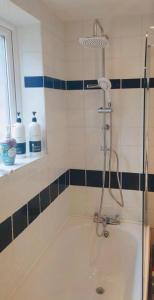 a bath tub with a shower in a bathroom at Cosy Cottage in Central Reading Free Parking & Fast Wifi in Reading