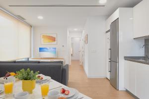een woonkamer met een bank en een tafel met eten bij Elite Beach in Málaga