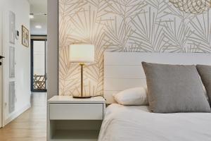 een slaapkamer met een bed en een tafel met een lamp bij Elite Beach in Málaga