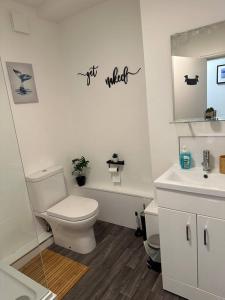 La salle de bains blanche est pourvue de toilettes et d'un lavabo. dans l'établissement Cosy authentic flat in the heart of Galashiels, à Galashiels