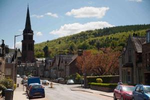 a street in a small town with a church at Cosy authentic flat in the heart of Galashiels in Galashiels