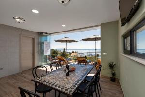 a dining room with a table and chairs and a balcony at Villa Teraco in Makarska