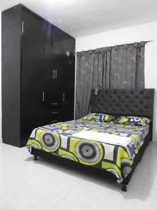 a bedroom with a bed and a black cabinet at Apartamento familiar Obdulio in Villavicencio