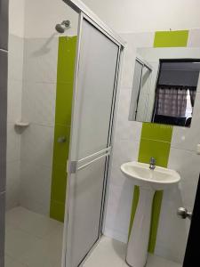 a white bathroom with a sink and a shower at Apartamento familiar Obdulio in Villavicencio