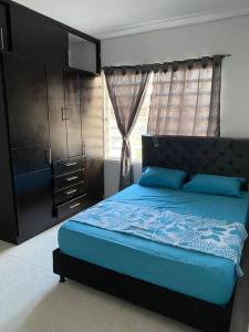 a bedroom with a blue bed and a window at Apartamento familiar Obdulio in Villavicencio